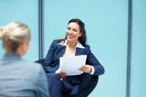 Portrait of pretty business woman discussing with executive in office